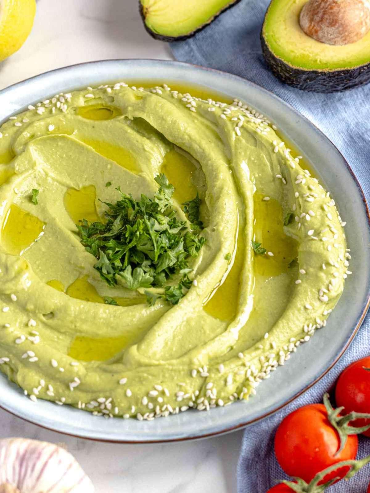 Avocado-Aufstrich mit Olivenöl, Sesamsamen und Petersilie garniert.