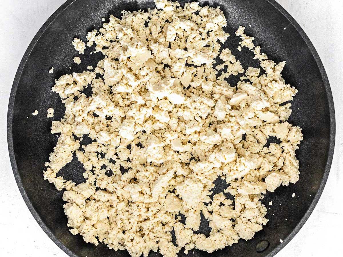 Tofu zerbröselt in einer Pfanne