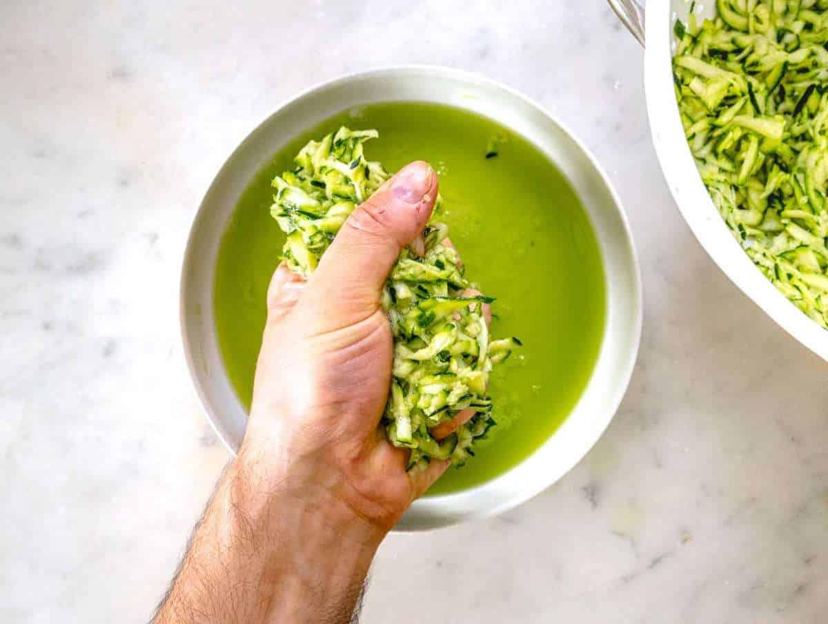 Schritt 2 Das Wasser aus der geriebenen Zucchini auspressen