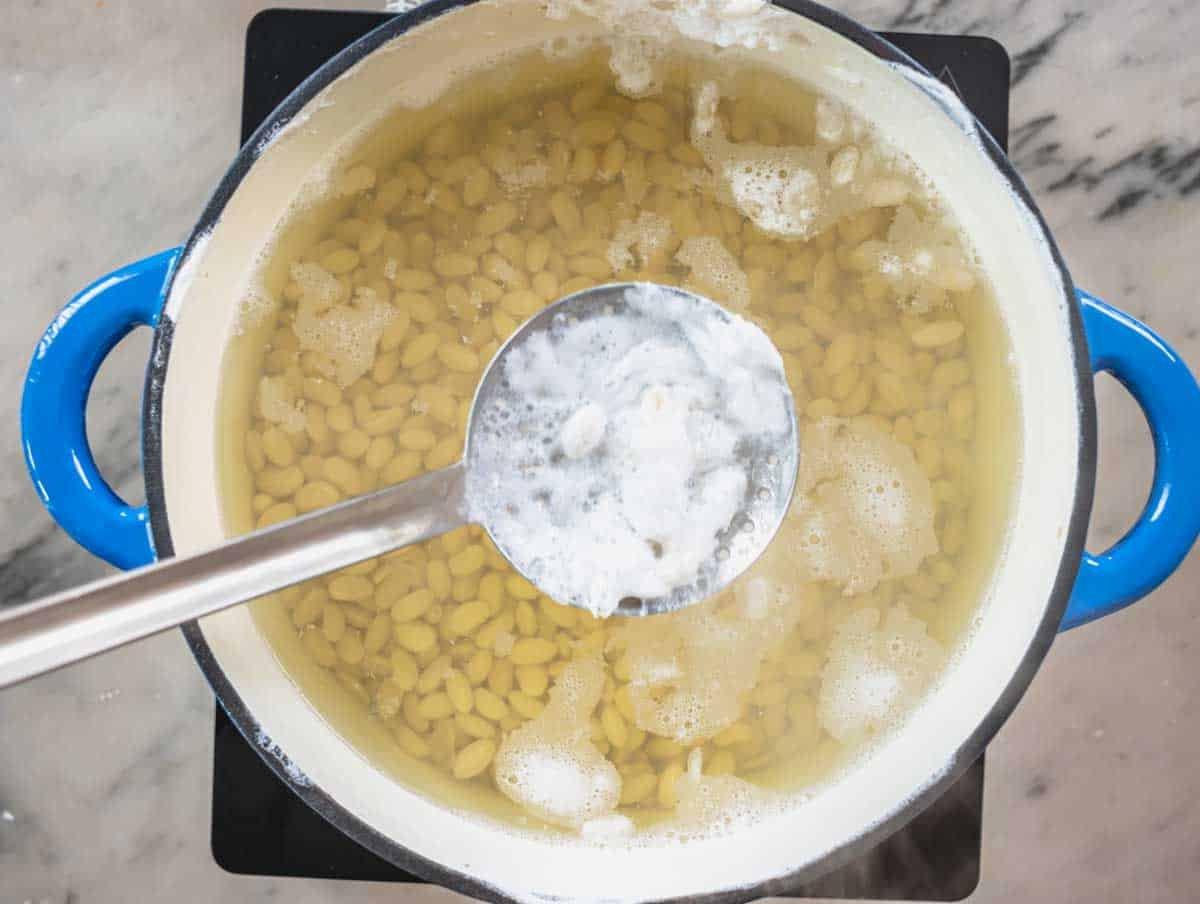 Weißer Schaum im Kochwasser mit weißen Bohnen
