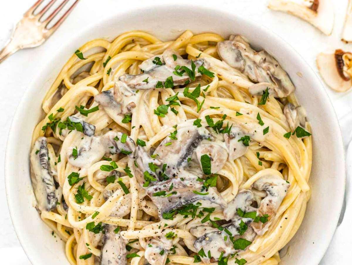 Pilz-Alfredo 6 mushroom alfredo sauce with spaghetti in a bowl.