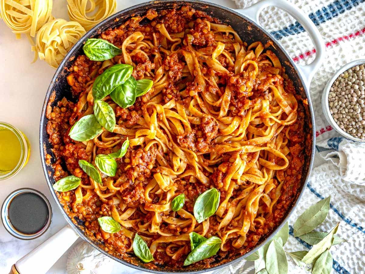 Linsen-Bolognese mit Pasta in einer weißen Pfanne