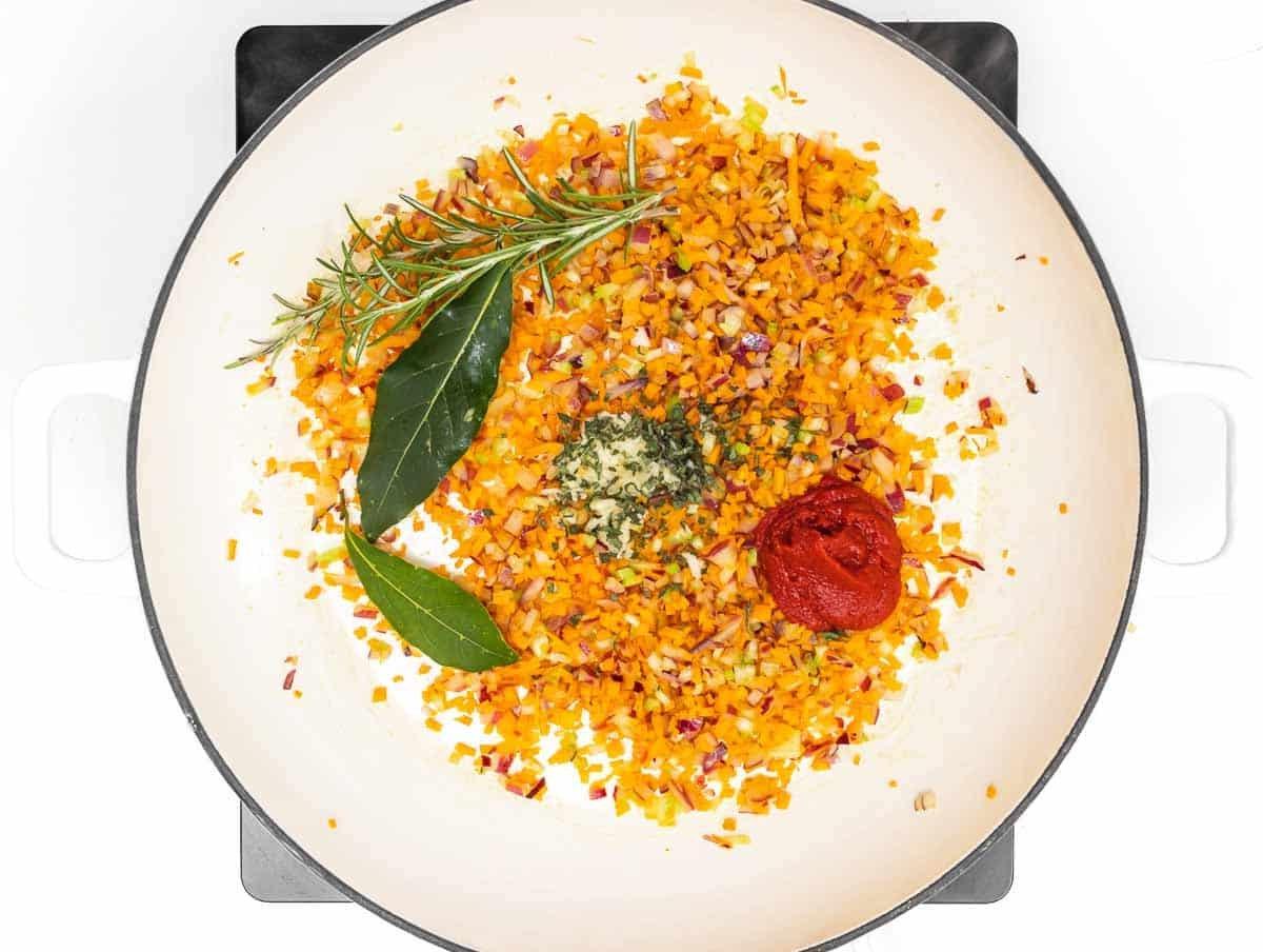 frische Kräuter und Tomatenpüree im Topf