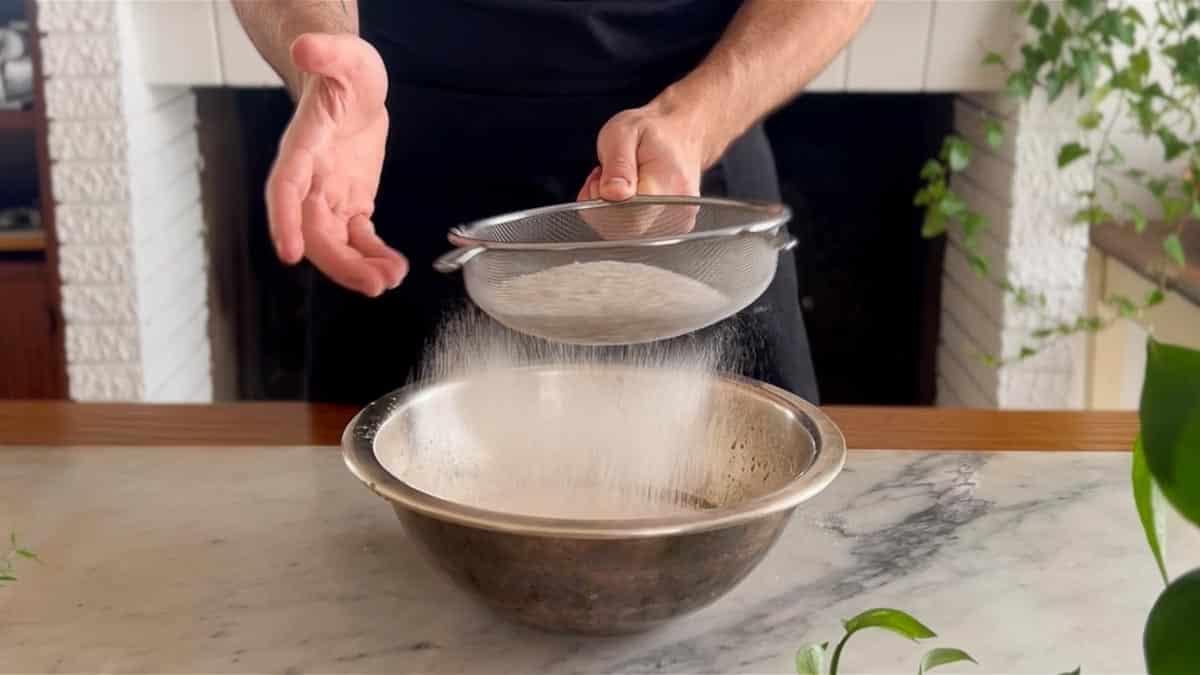 sifting flour and baking powder into the wet ingredients