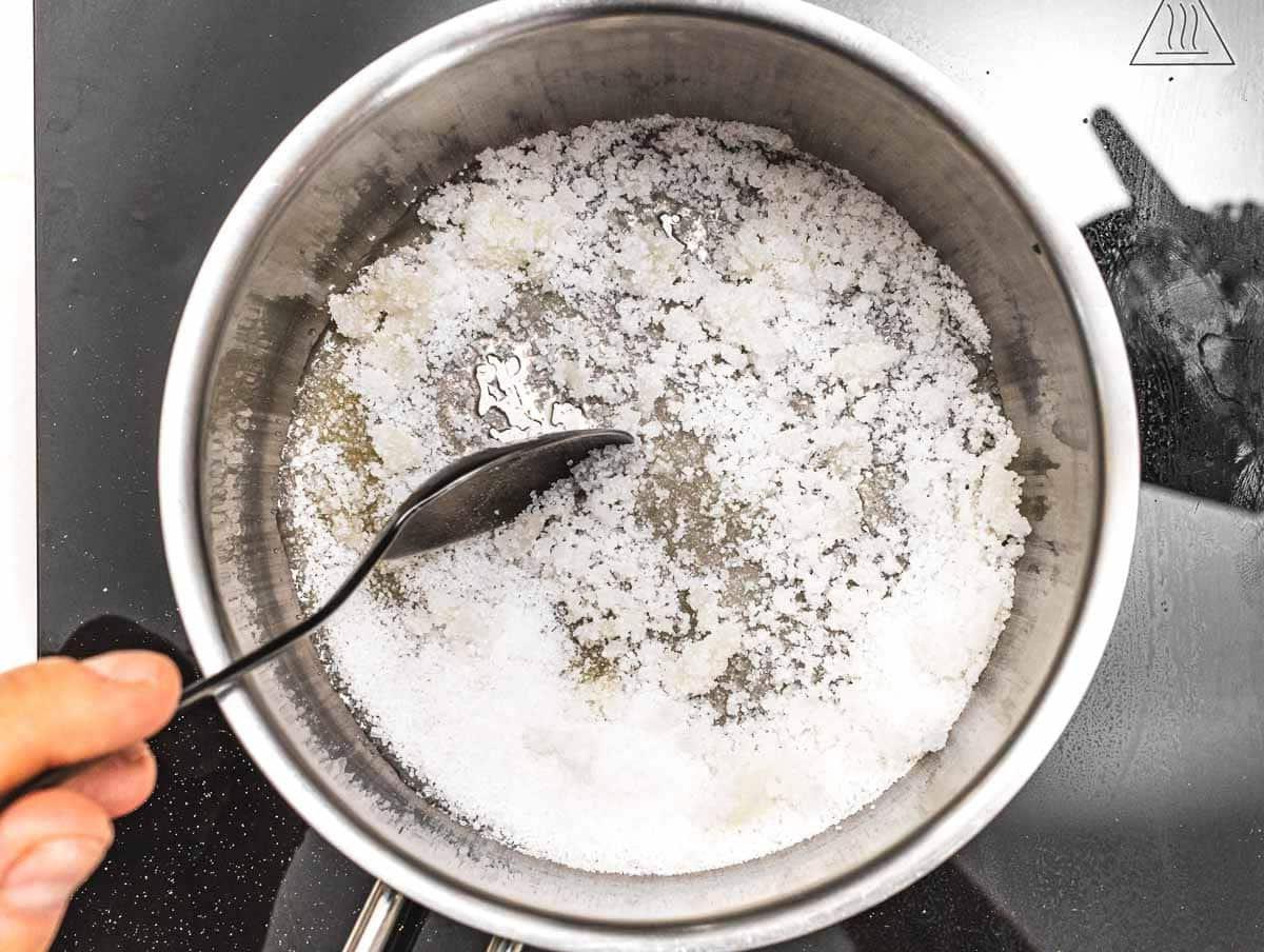 Zucker schmilzt im Topf zu goldbraunem Karamell