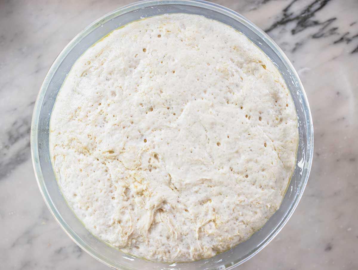Aufgegangener Focaccia-Teig in einer Schüssel, Volumen verdoppelt.