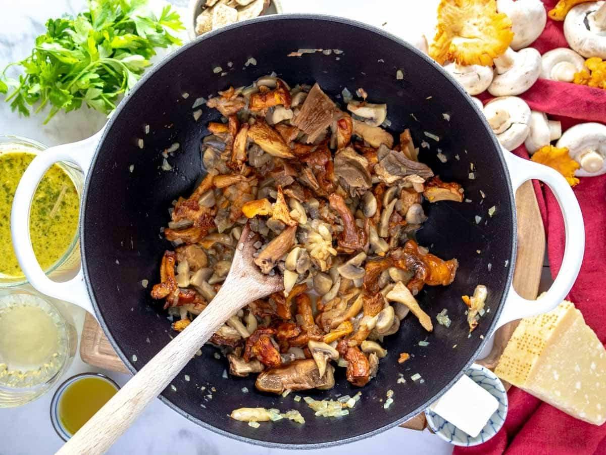 angedünstete Pilze in einem Topf mit Zwiebeln und Knoblauch