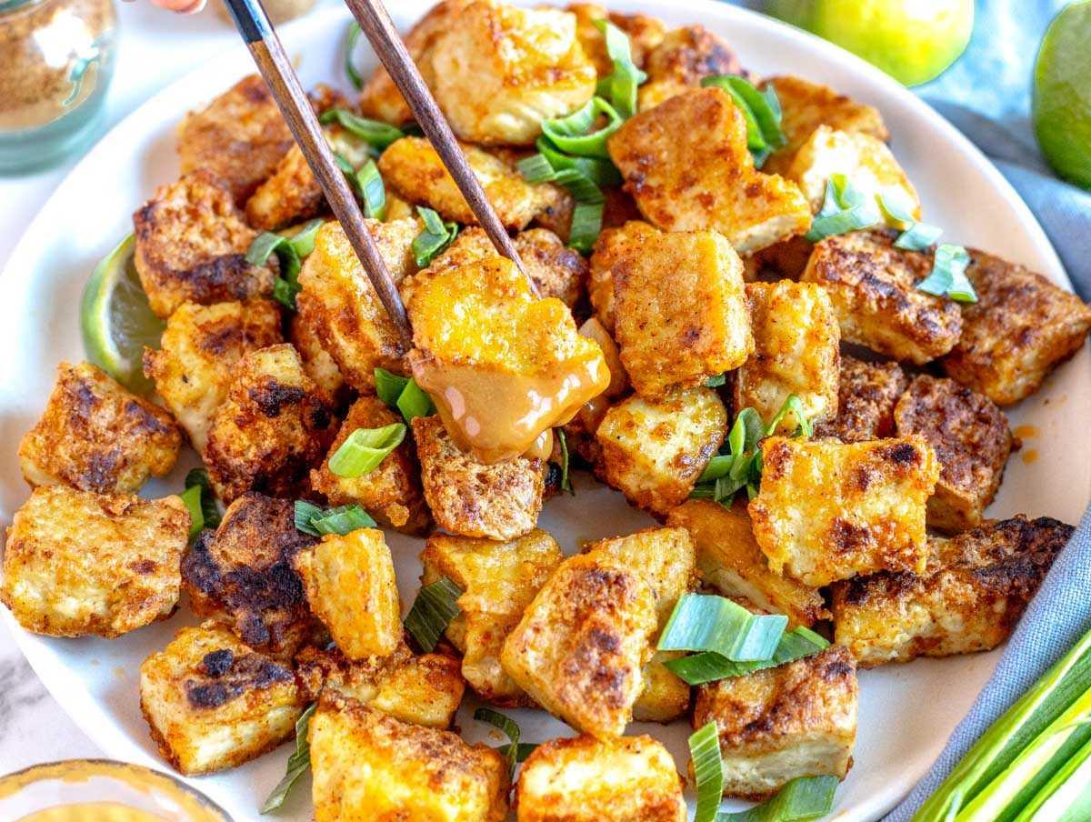 In Erdnusssauce getauchtes, in der Pfanne gebratenes Tofu.