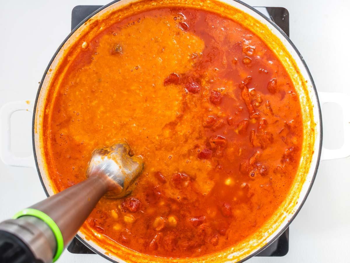 Pasta e Ceci (Nudeln mit Kichererbsen) 7 Stabmixer in einer Pfanne zum Pürieren von Tomatensauce und Kichererbsen