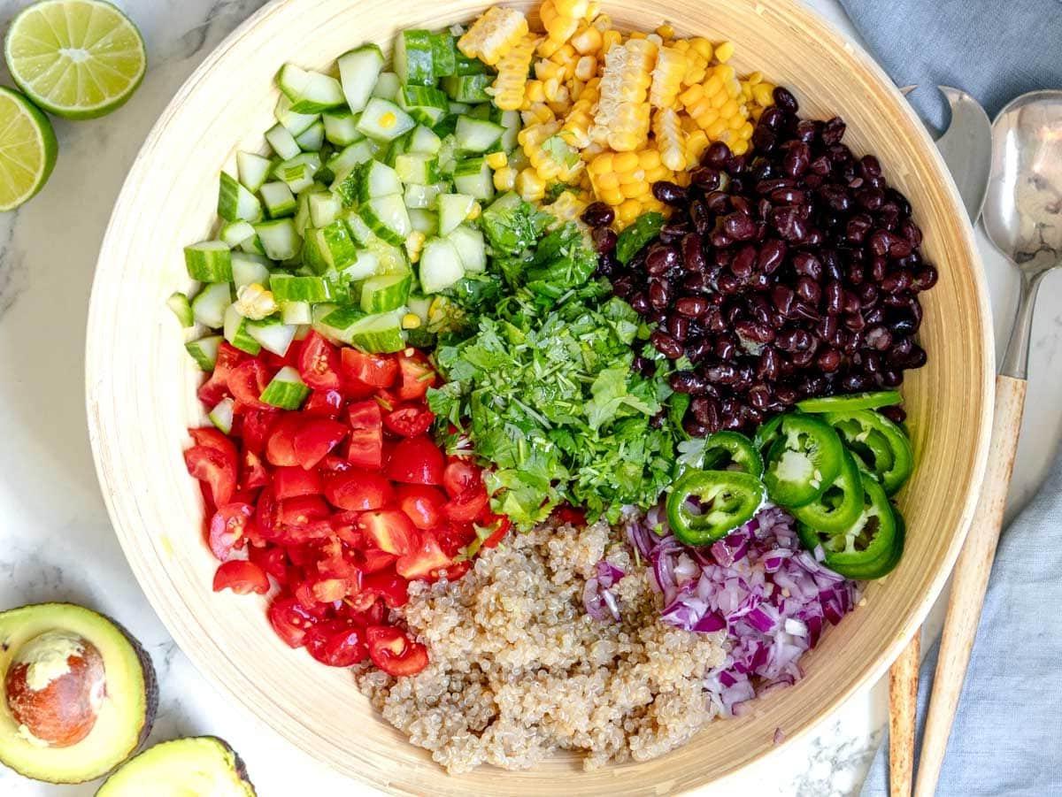 Gehacktes Gemüse und Quinoa in einer großen Rührschüssel, bereit zum Mischen.