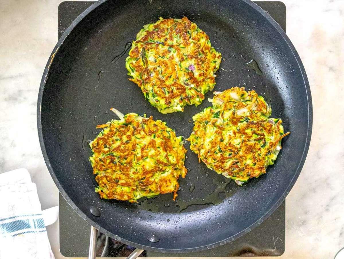Schritt 4 Die Zucchinipuffer in einer Pfanne mit Olivenöl braten.