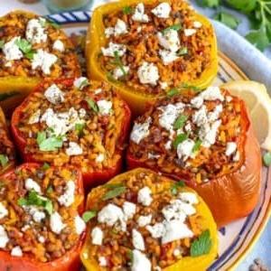 Ofengebackene mediterrane gefüllte Paprika, gefüllt mit Reis, Linsen und Kräutern, serviert als vollwertiges und farbenfrohes vegetarisches Hauptgericht.