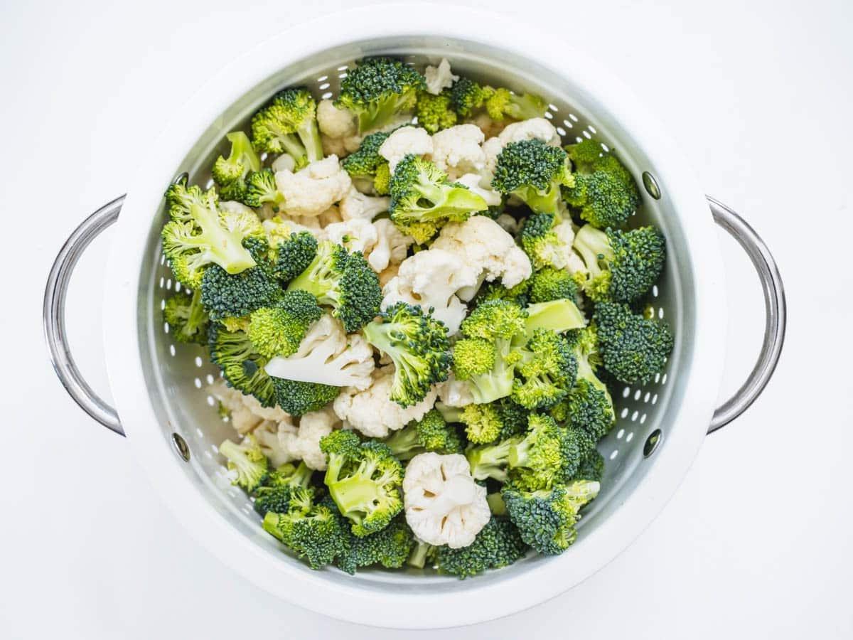 broccoli and cauliflower florets in a steamer basket