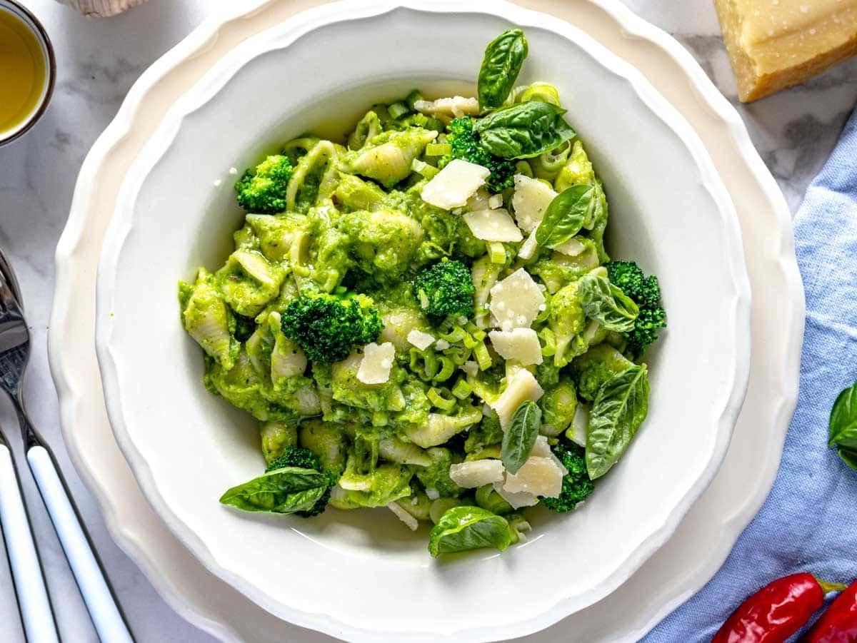 Angerichtete Brokkoli Pasta mit Basilikumblättern und gehobeltem Parmesan