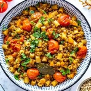 Linsenpasta in einer Schüssel mit frischer Petersilie und einem Löffel.