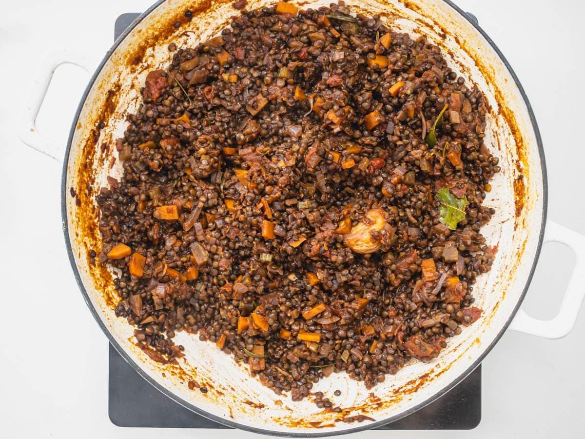 Schwarze Linsen in einer weißen Pfanne