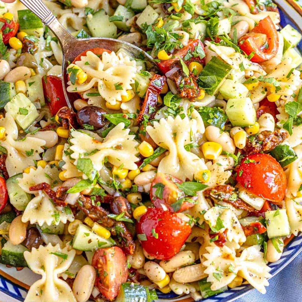 Farbenfroher veganer Nudelsalat mit bunter Schleifenpasta.