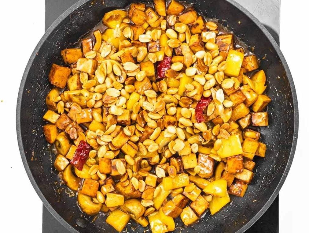 Erdnüsse zu Tofu und Gemüse hinzufügen.