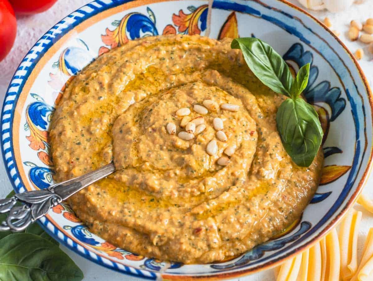 Rotes Tomatenpesto in einer mediterranen Schüssel mit Basilikum