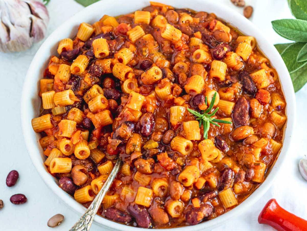 Pasta und Fagioli in einer weißen Schüssel mit einem Silberlöffel