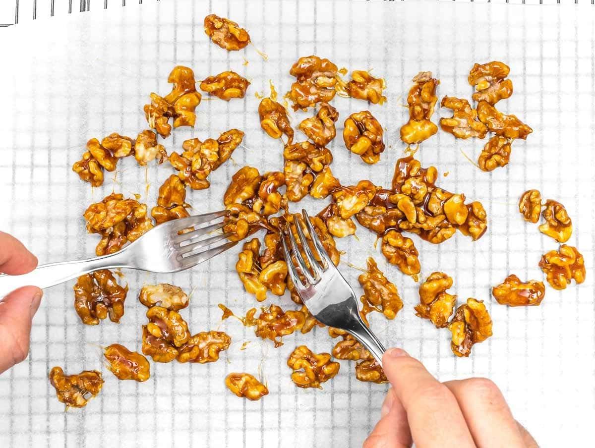 Zuckerüberzogene Walnüsse auf Backpapier trennen