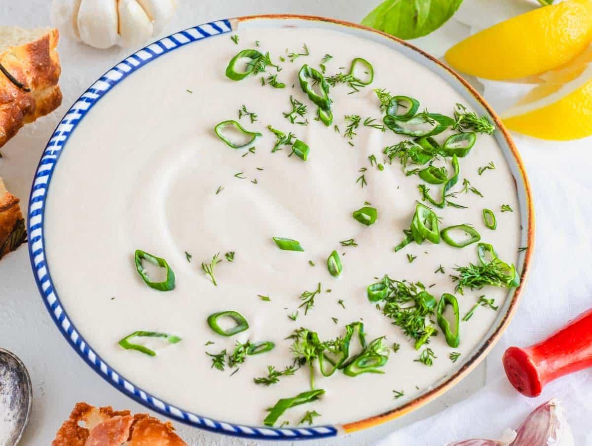 Weißbohnendip in einer mediterranen Schüssel mit Lauchzwiebeln und Dill