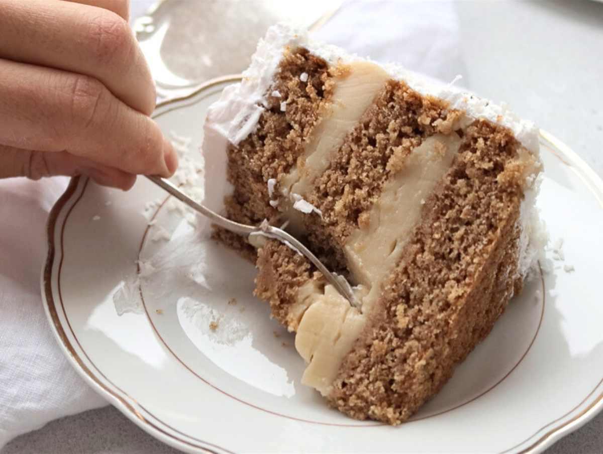 Veganer Kokoskuchen 10 Veganer Kokoskuchen angeschnitten, mit einer Gabel bereit zum Genießen