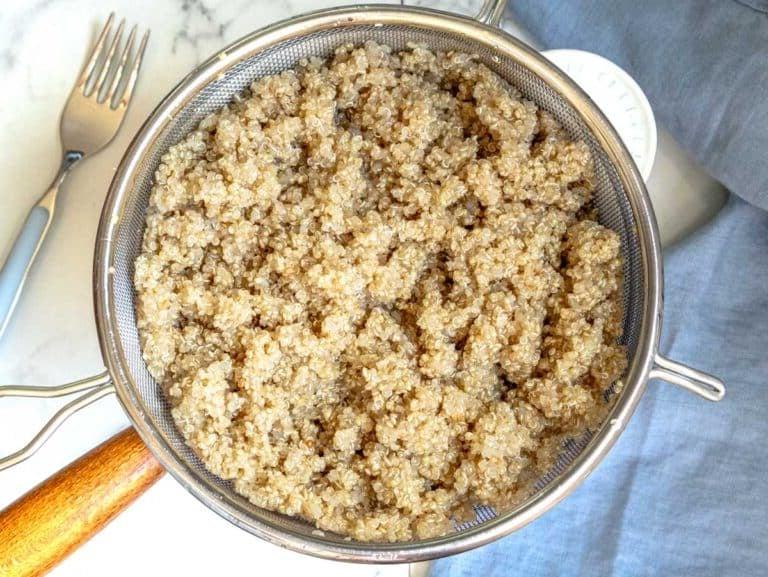 Quinoa in einem feinen Sieb über einem Topf abtropfen lassen.