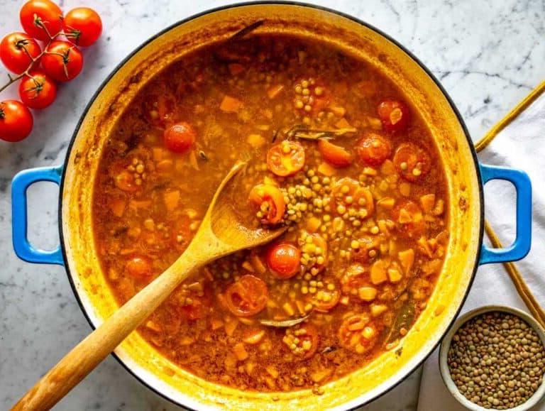 Linsen in Brühe mit Tomaten köcheln lassen.