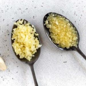 Knoblauch hacken und Knoblauchpaste herstellen 9 gehackter Knoblauch auf schwarzen Löffeln