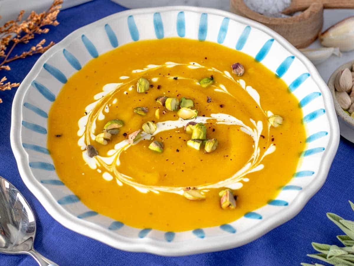 Butternut squash soup topped with nuts and cream.