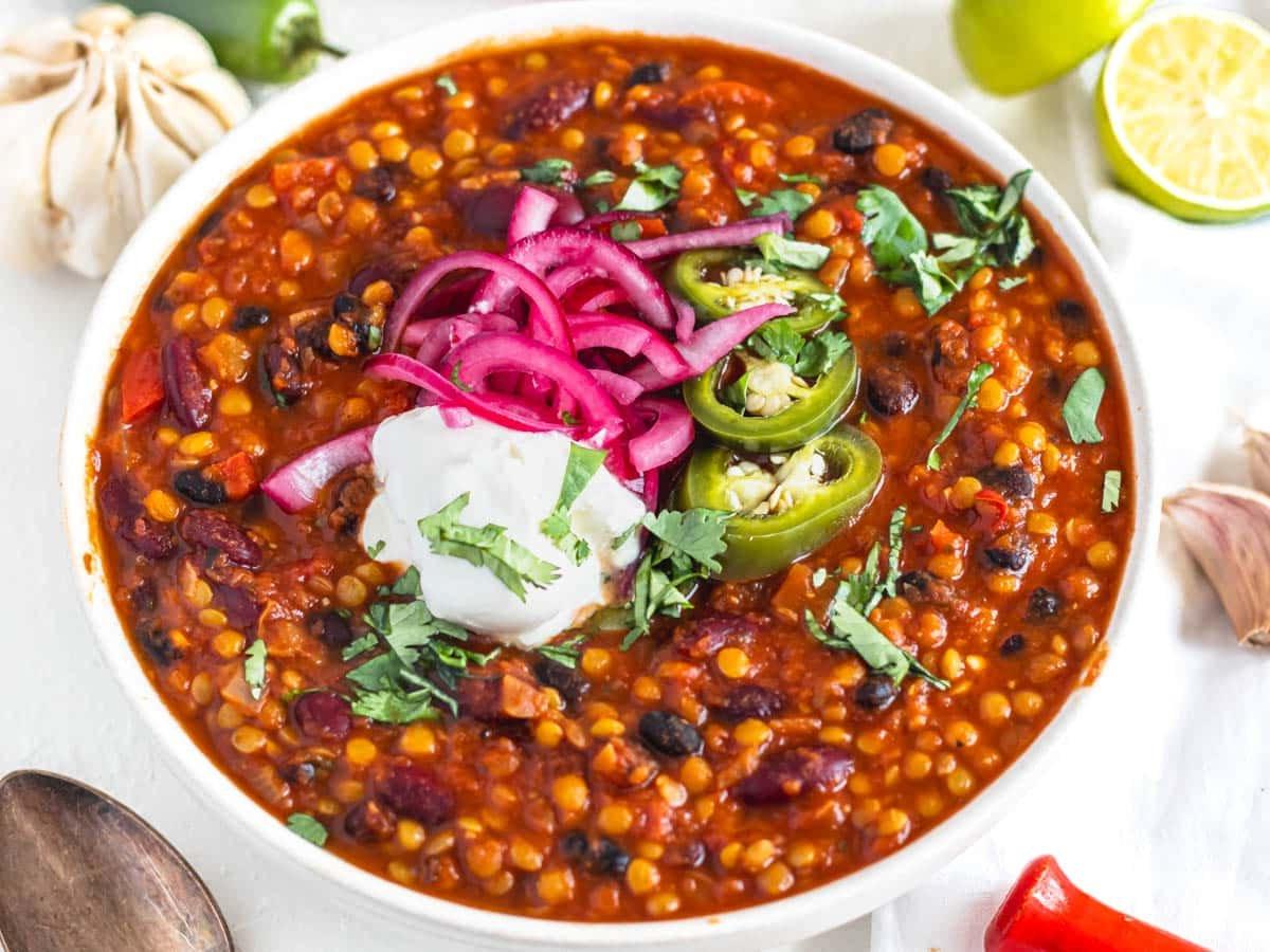 lentil chili with sour cream and pickled jalapenos in a bowl