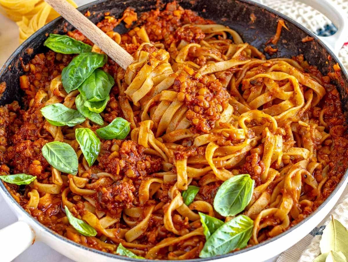Linsen-Bolognese mit Pasta in einer weißen Pfanne