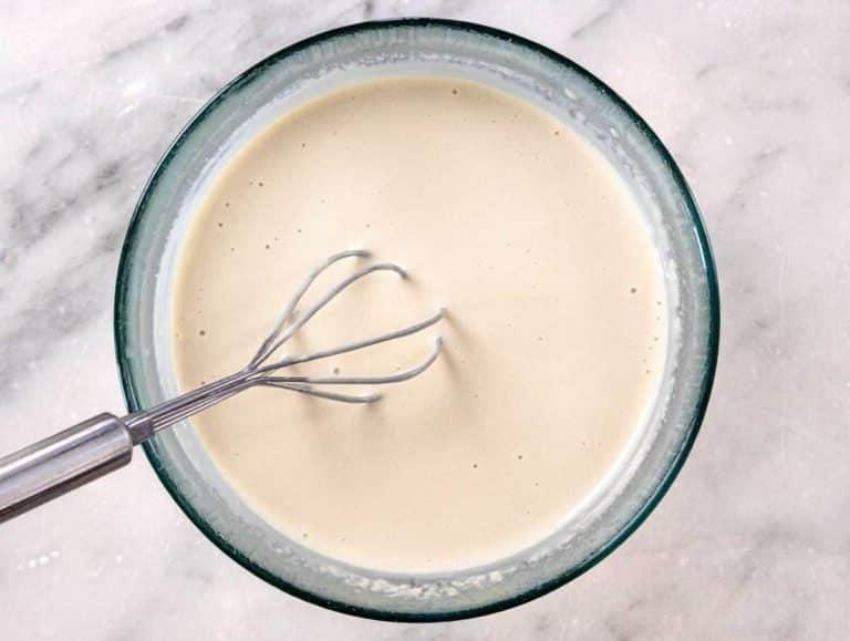 Zubereitung des Tahini-Dresings, fertig verquirlt in einer Glasschüssel.